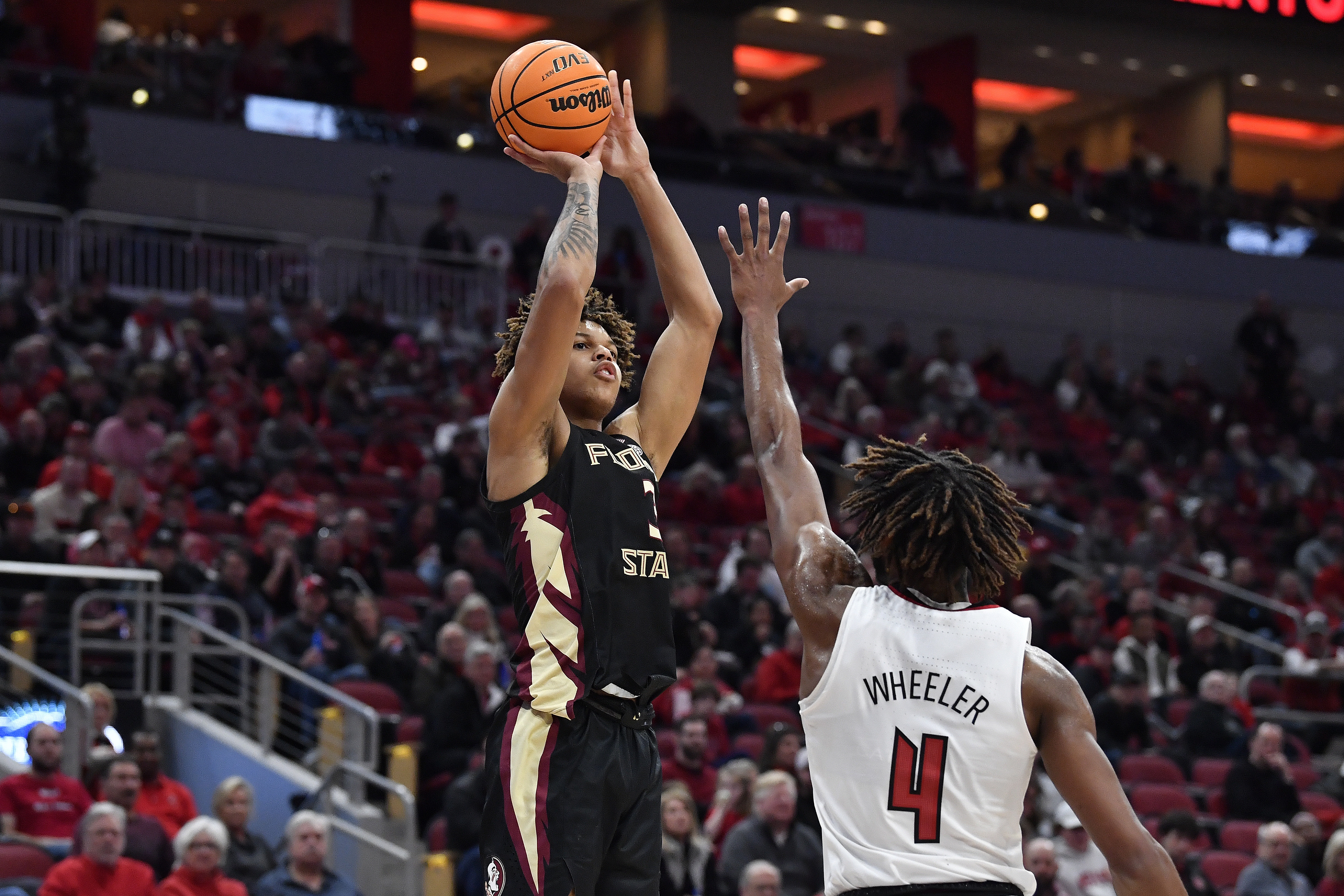 Florida State forward Cam Corhen (L), shoots over Louisville forward Roosevelt Wheeler during an NCAA college basketball game in Louisville, Ky., Feb. 4, 2023. Corhen says he experienced online harassment when he played basketball at FSU.